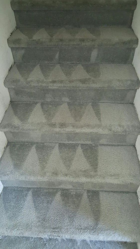 Eco Friend Carpet Clean - Gray carpeted staircase with repeated triangular patterns.