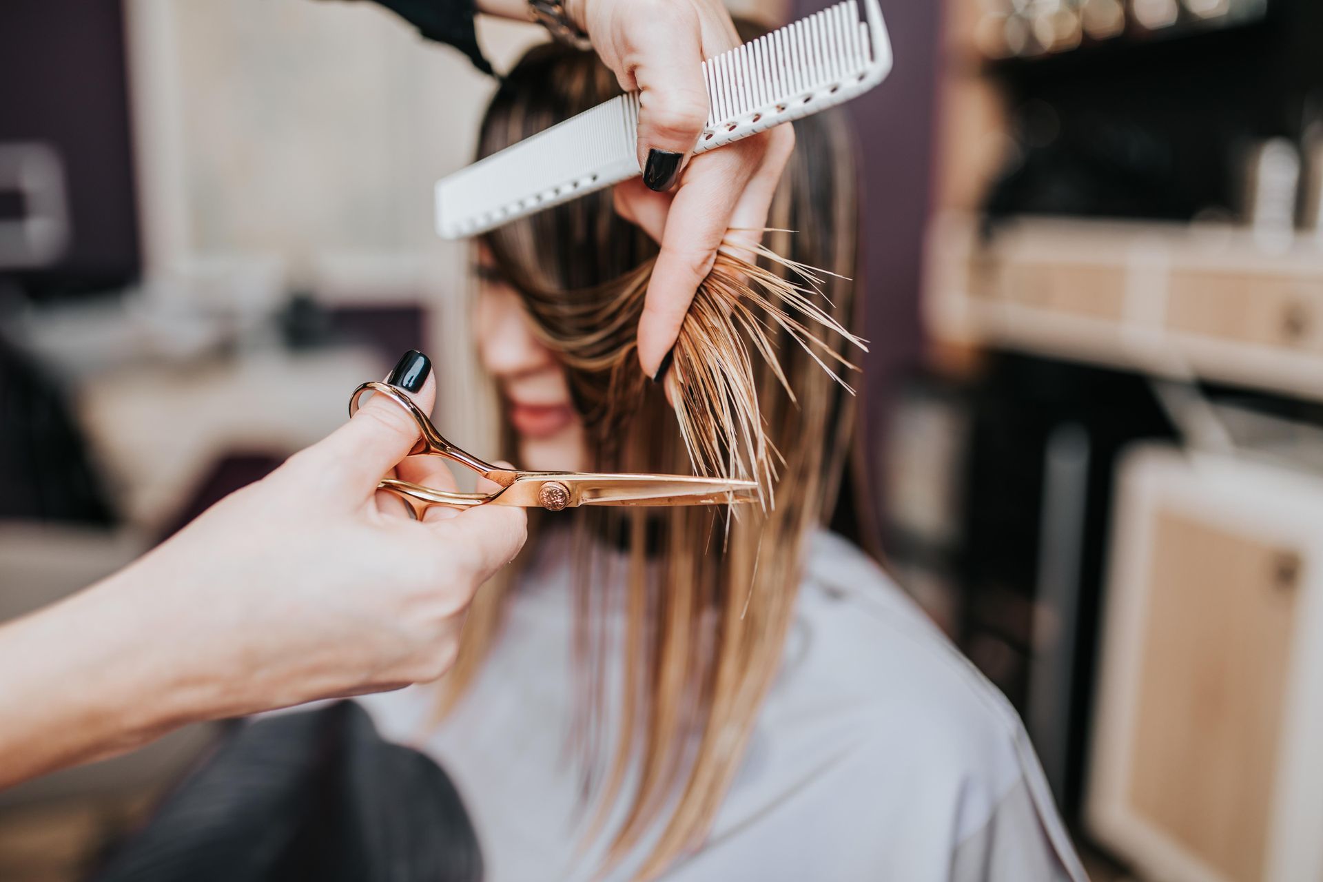 a woman is getting her hair cut by a hairdresser in a salon .