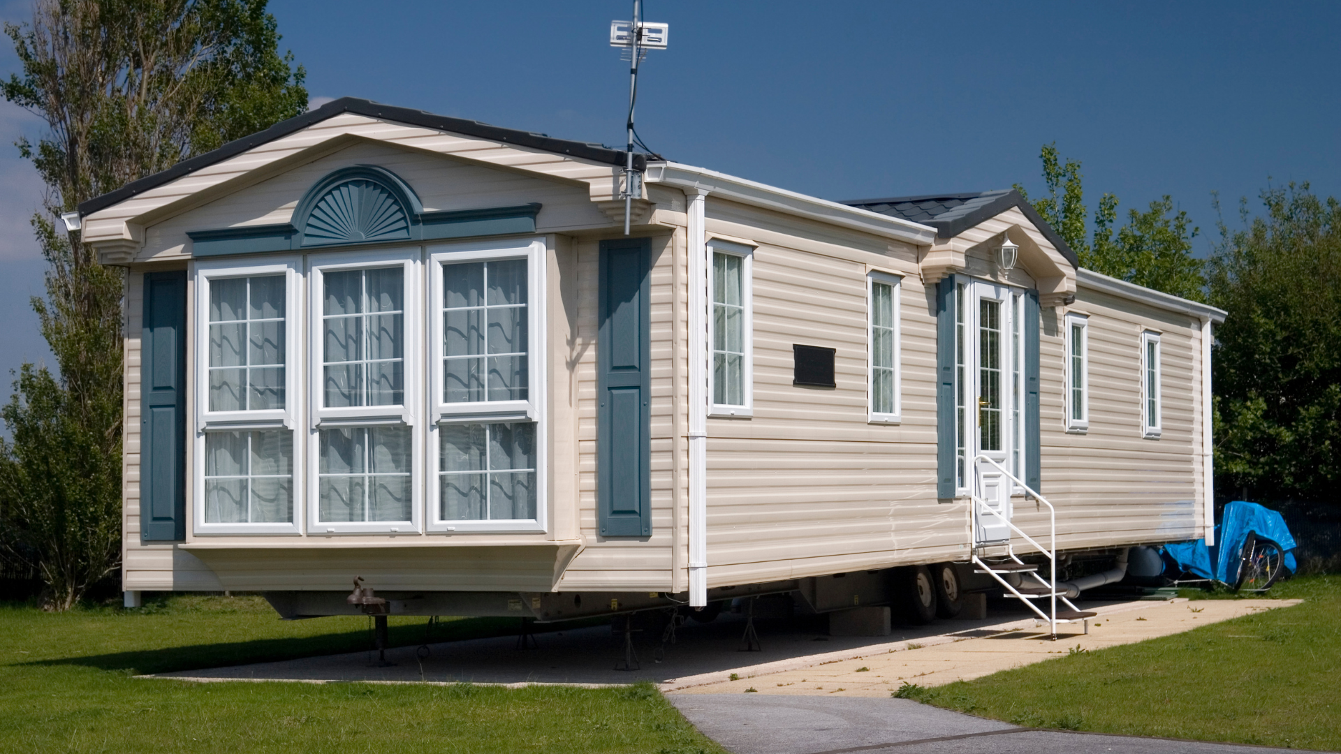 A mobile home is parked in a grassy field.
