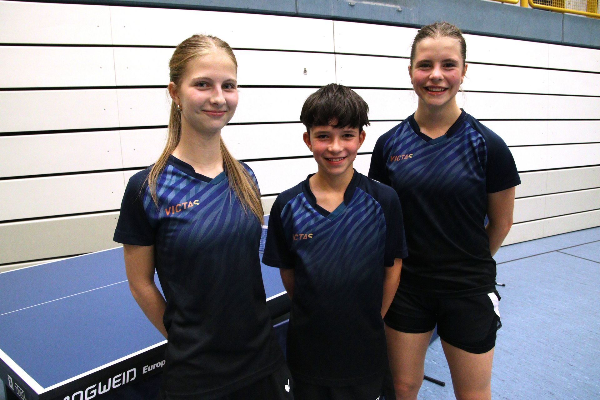 Eine Gruppe junger Leute steht um einen Tischtennistisch herum