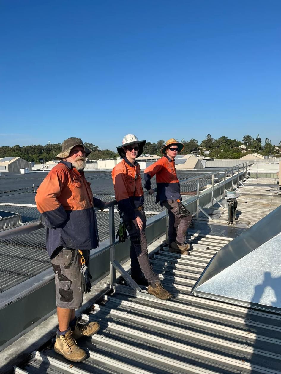 Three Men Are Standing on the Roof of a Building — Depinto Agencies In North Mackay, QLD