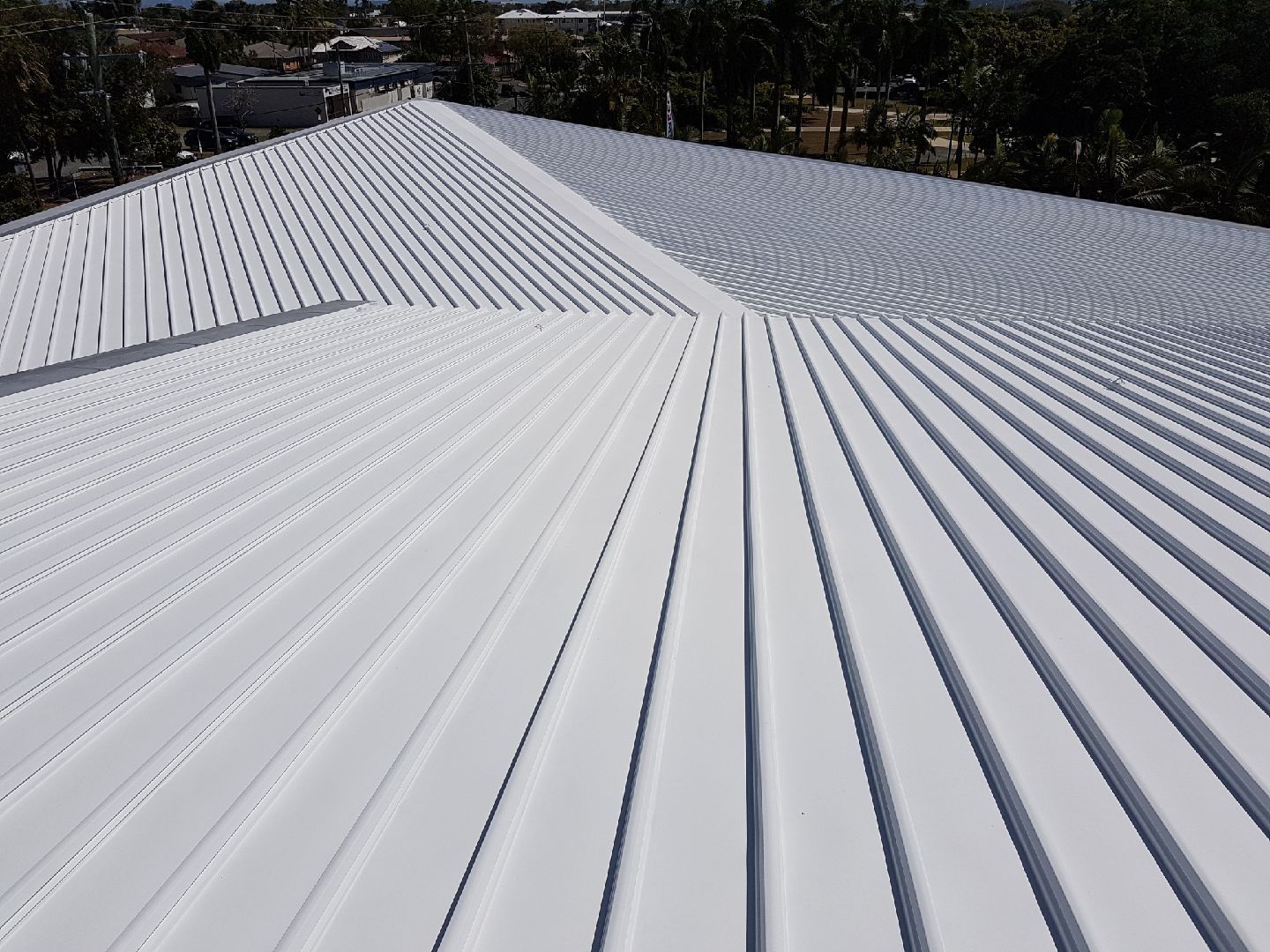 White corrugated metal roof with a central ridge, viewed from above outdoors — Depinto Agencies In North Mackay, QLD