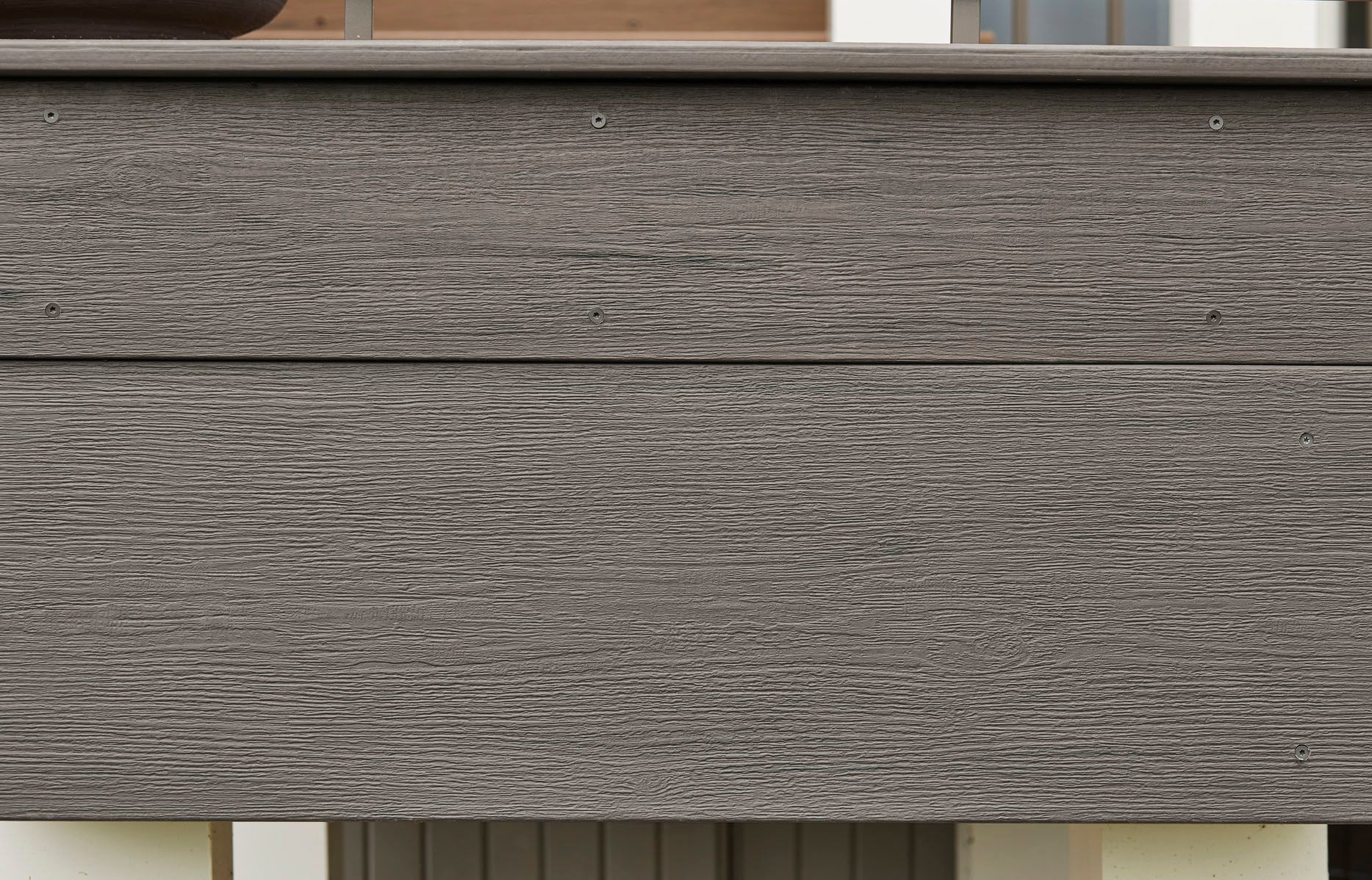 A close up of a gray wooden surface with a grainy texture.