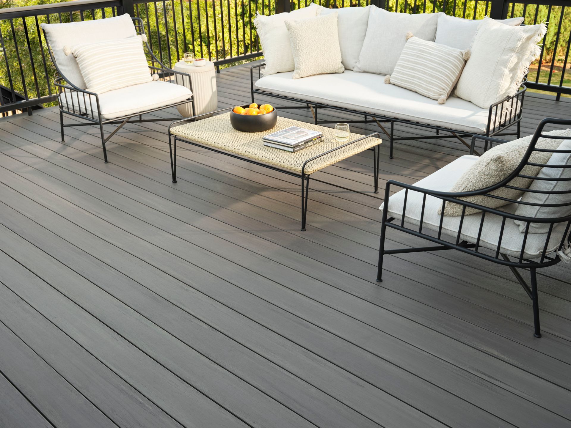 A deck with a couch , chairs and a coffee table
