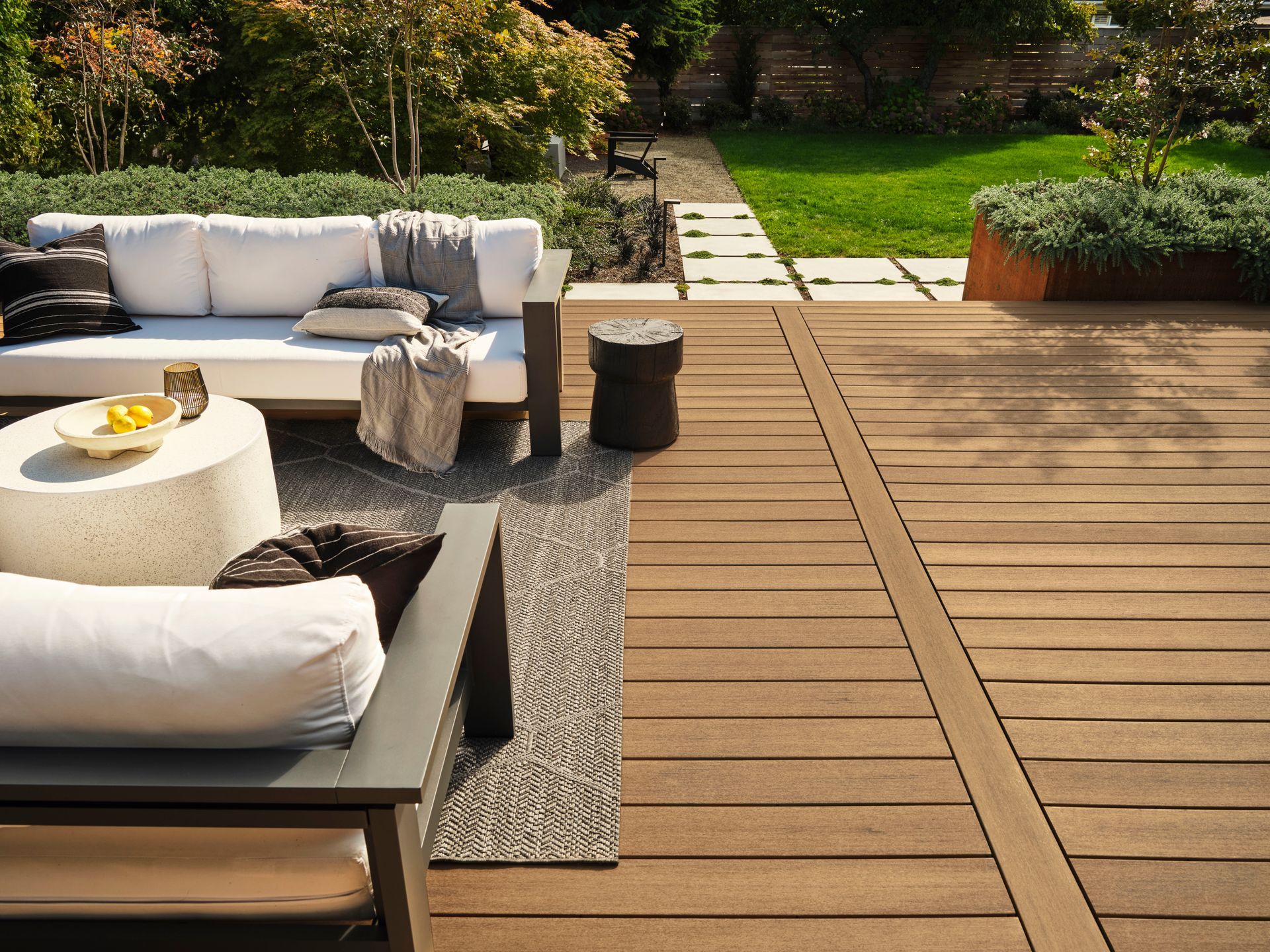 A wooden deck with a couch and chairs on it