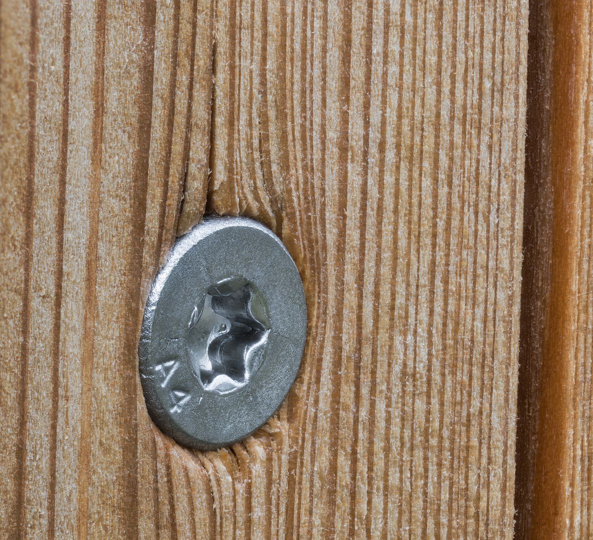 A close up of a screw in a piece of wood