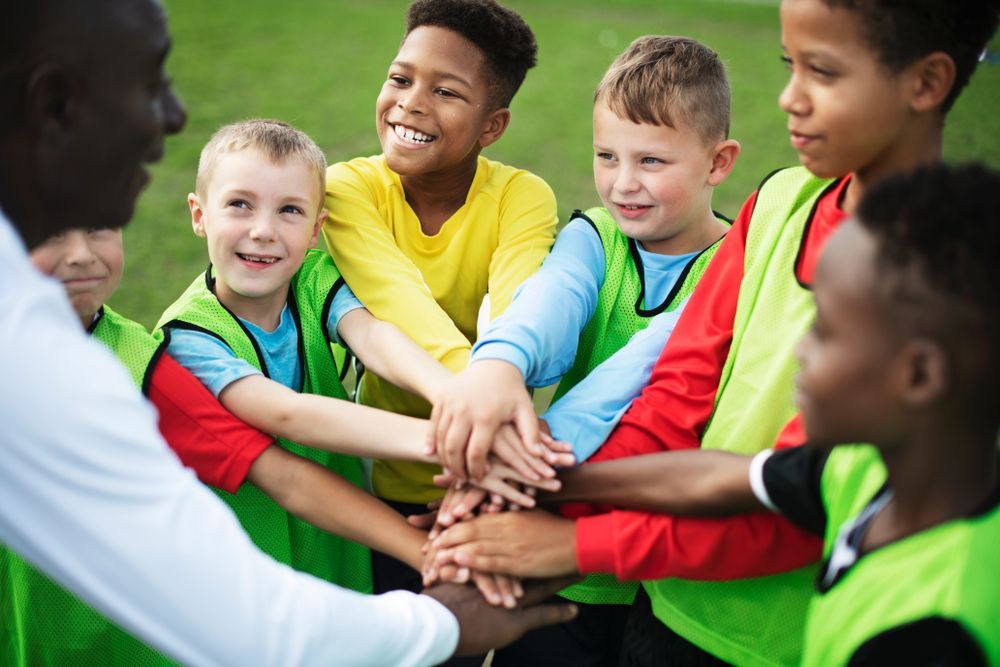 Junior football team stacking hands before a match
