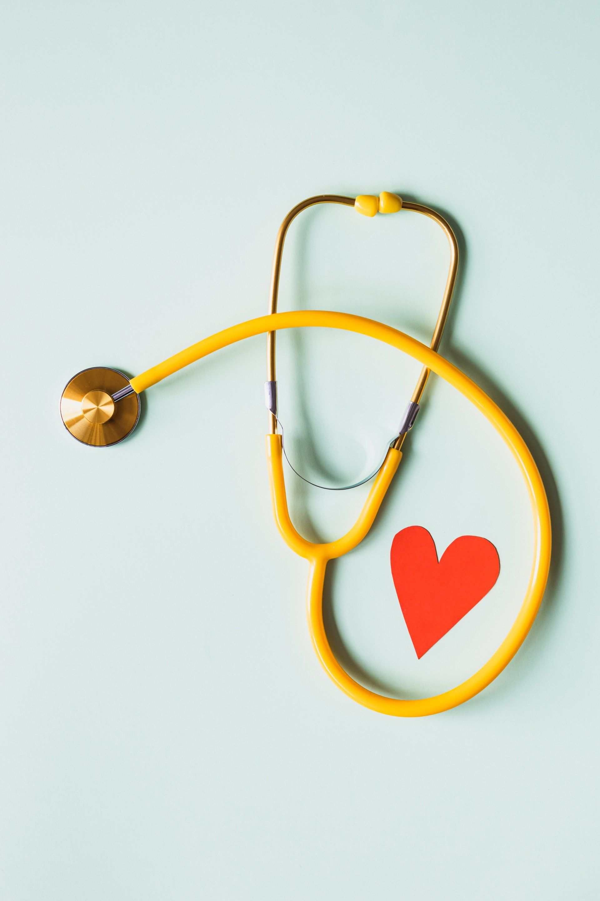 A yellow stethoscope with a red heart on it