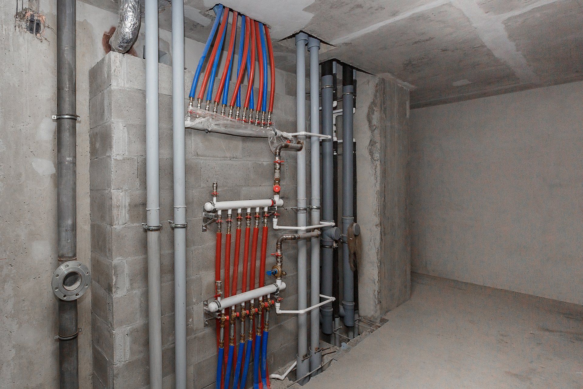 A room with a lot of pipes hanging on the wall.