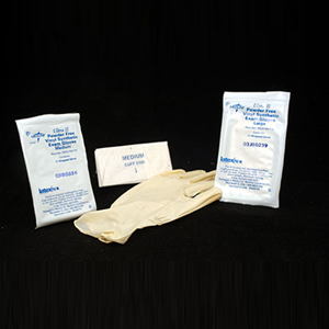 A pair of gloves sitting next to two packages of wipes