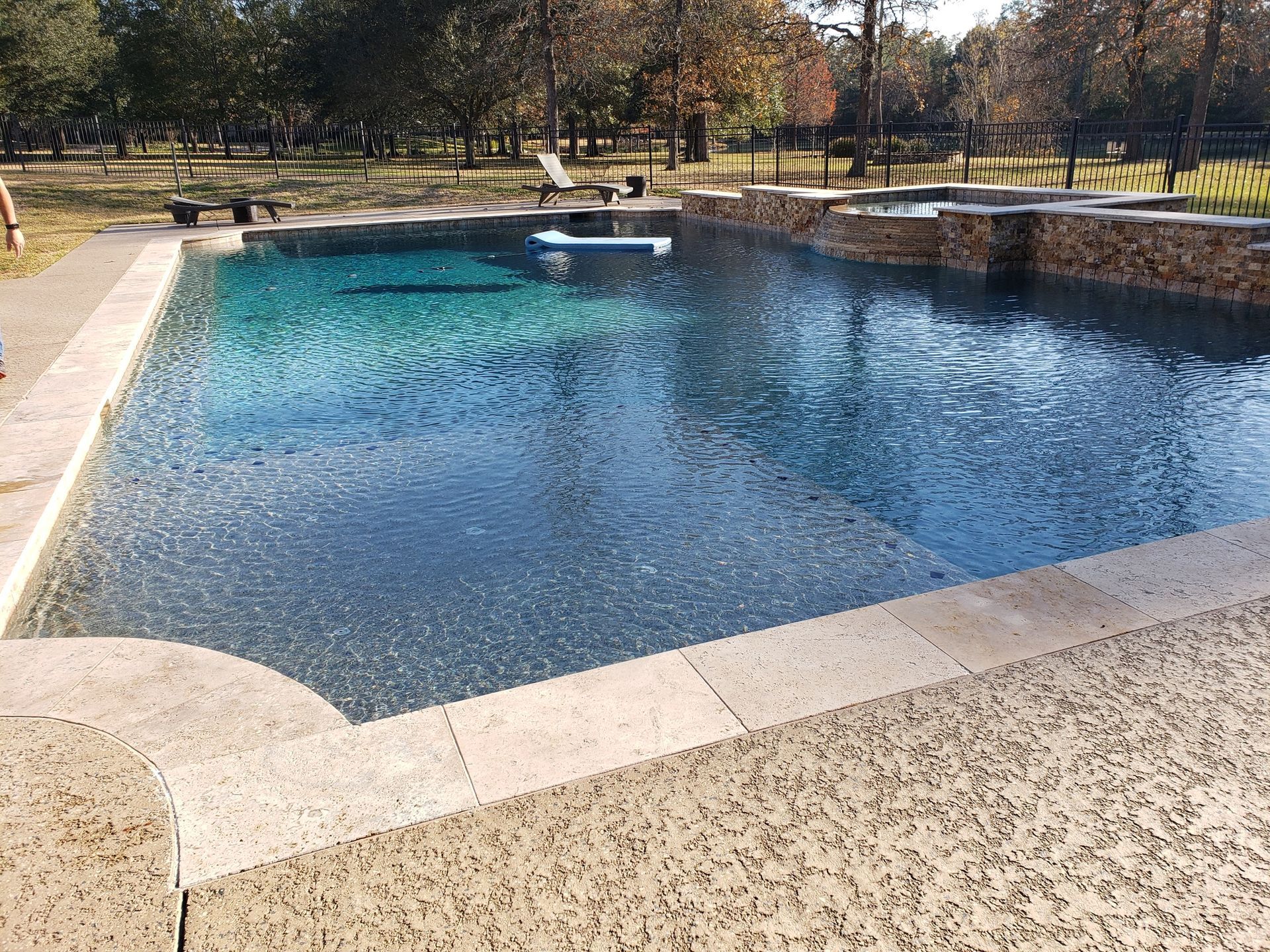 A large swimming pool with trees in the background