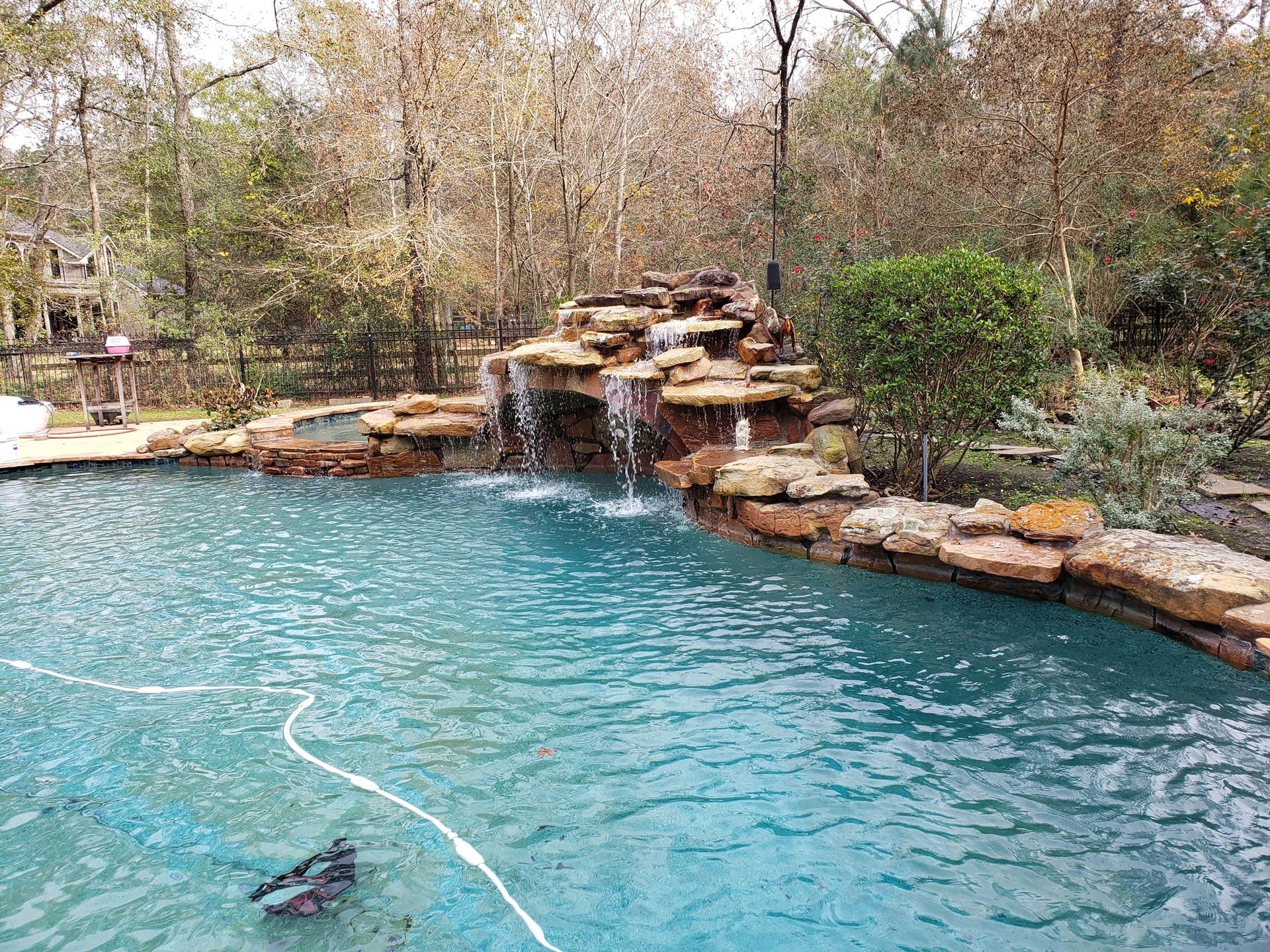 A large swimming pool with a waterfall in the middle of it.