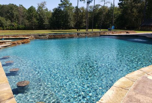 A large swimming pool with trees in the background