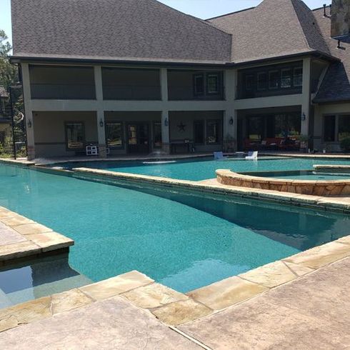 A large house with a large swimming pool in front of it.