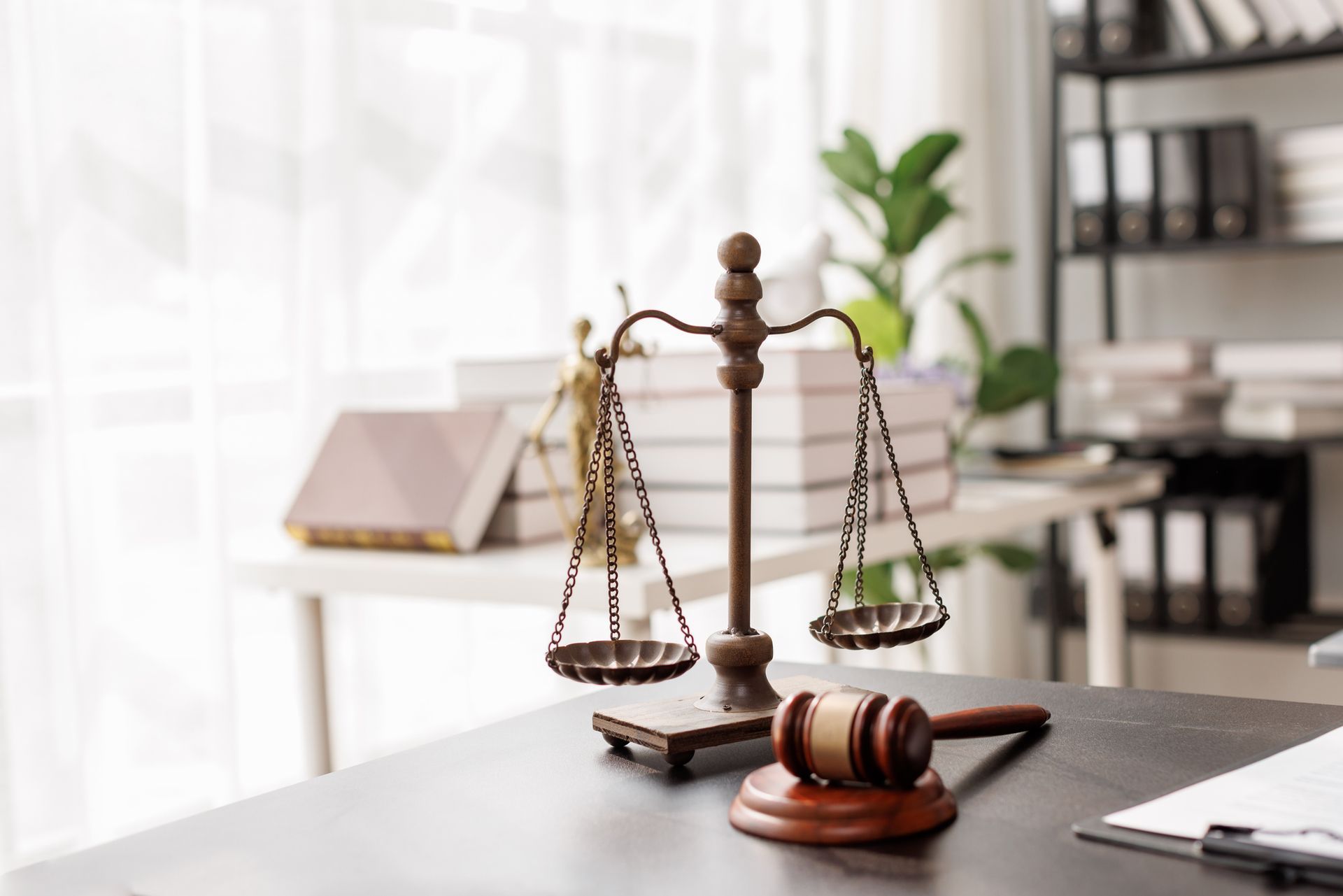 Law book with scales of justice and gavel on a desk in a bright office