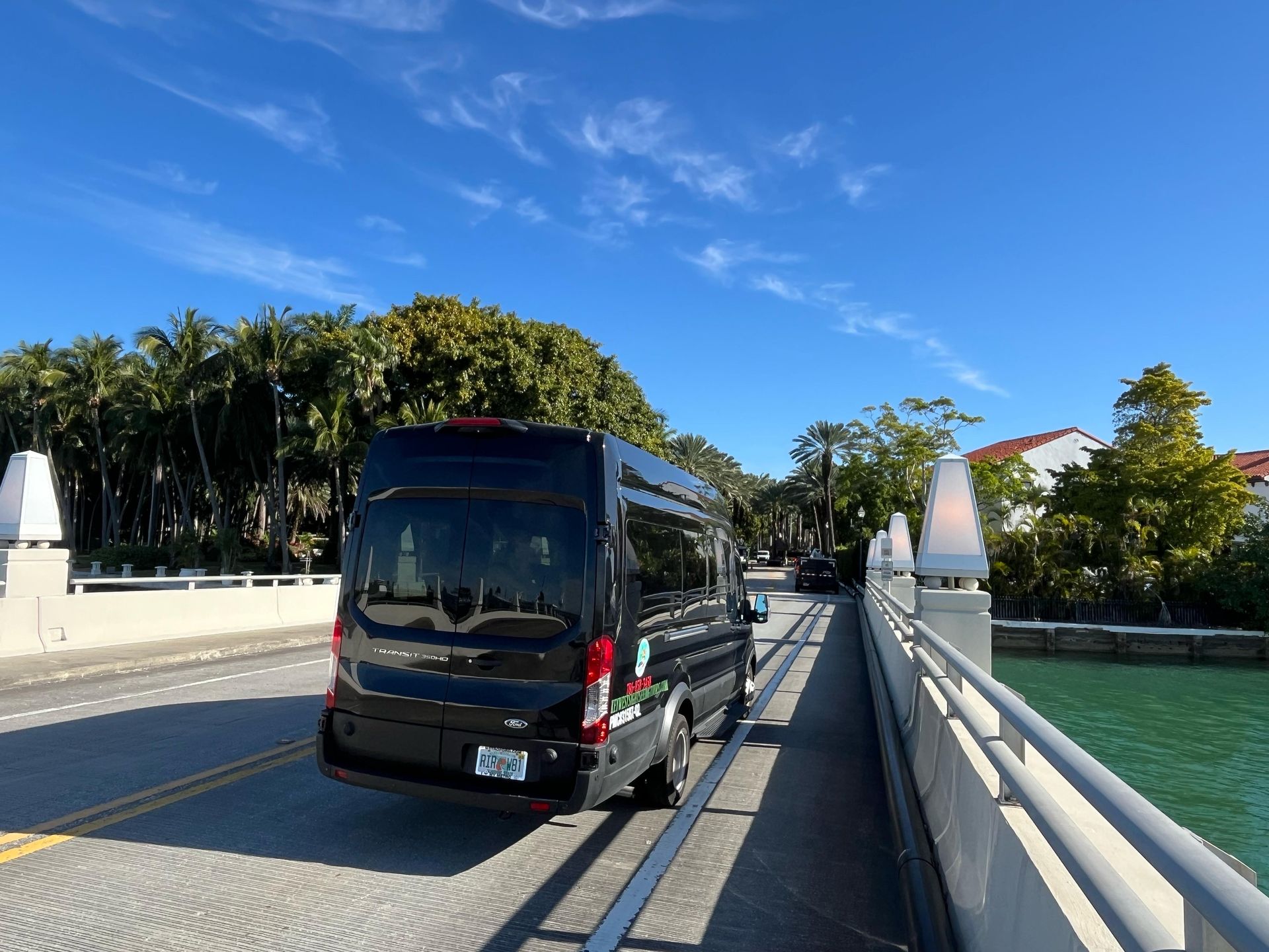 Black tour bus driving into Star Island on the small group Miami sightseeing tour
