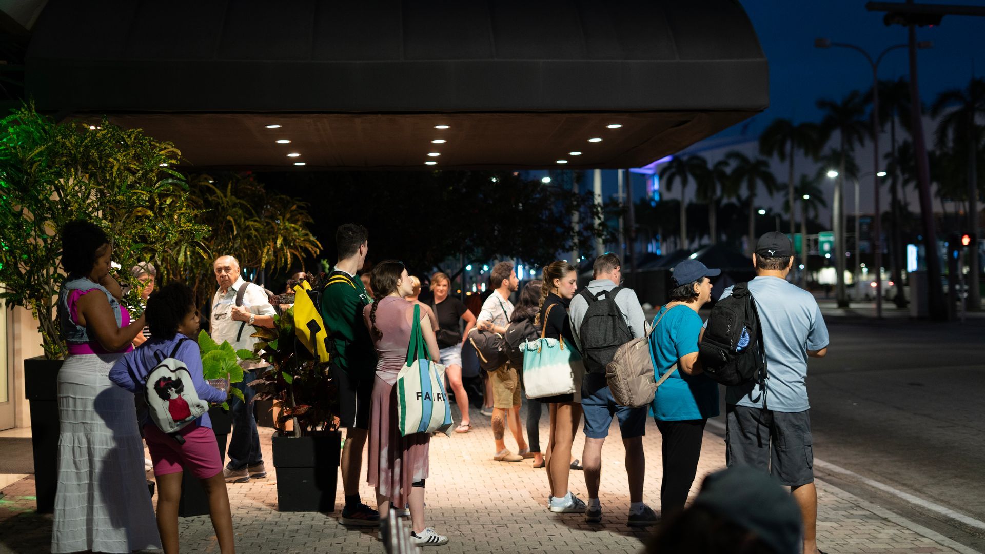 Early morning travelers lining up for the Miami to Key West bus tour at a downtown Miami pickup location
