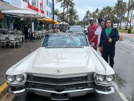 Tour guide and passengers in Ocean drive taking a photo with Tony Montana car of the Movie Scar Face, 
