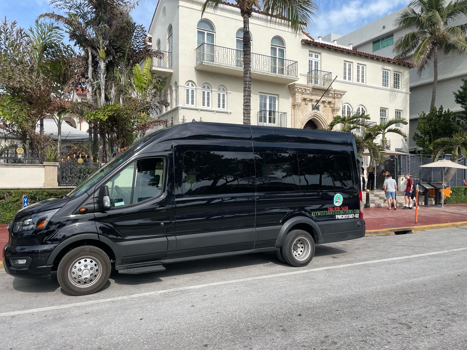 Miami City Tours in ocean drive with the Miami tour buses parked in front of the Versace Mansion. 