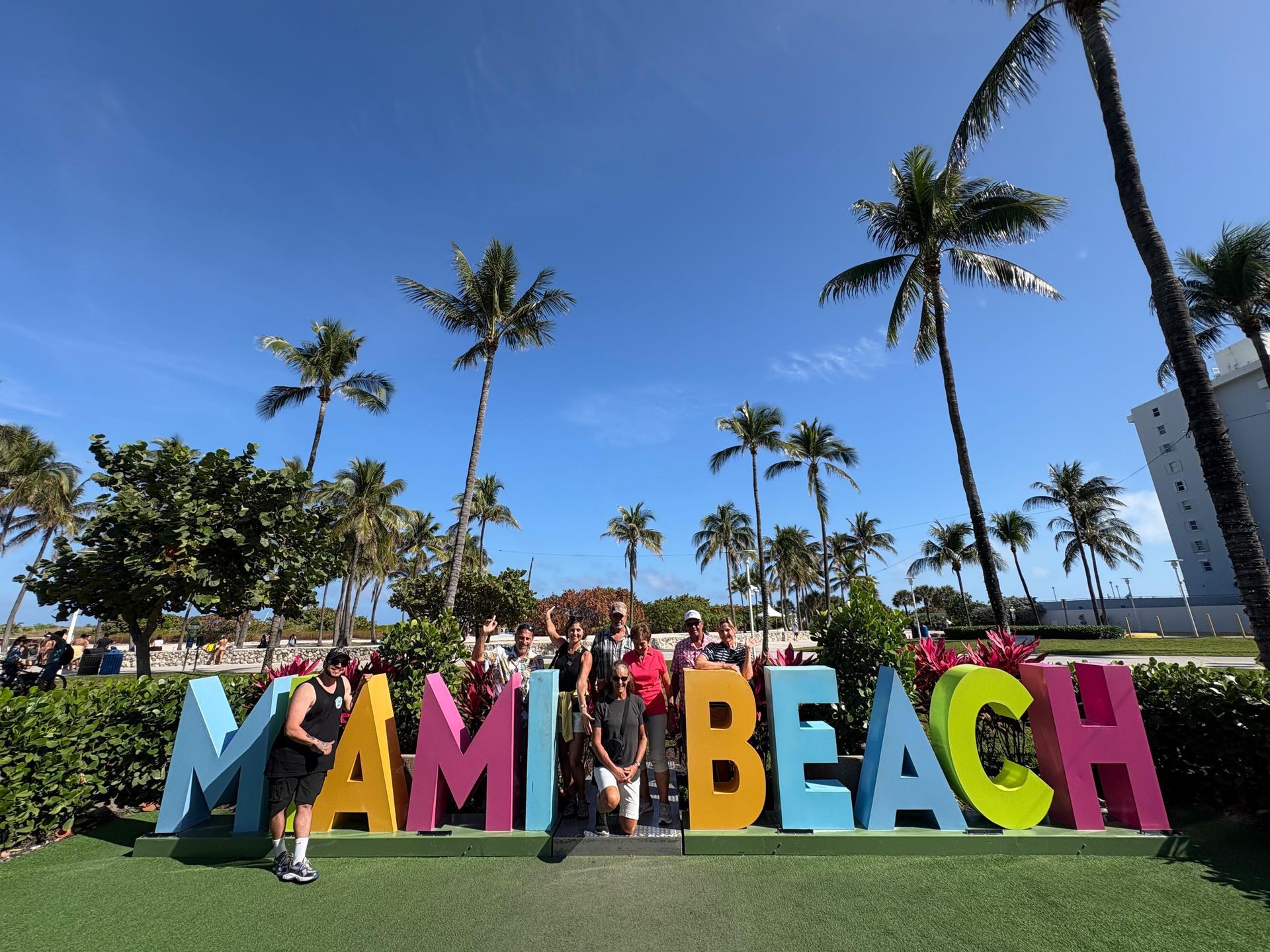 miami-tour-bus-passengers-group-photo-at-miami-beach-sign.jpg
