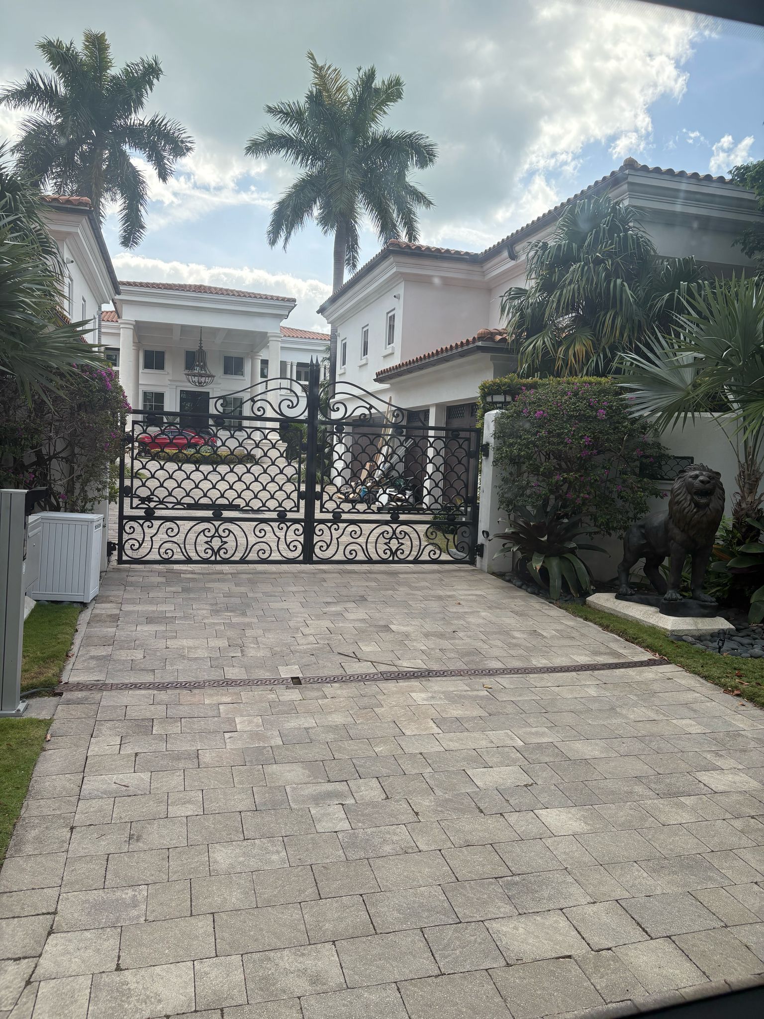 Front view of a luxury mansion with palm trees on Star Island, seen during the Miami Tour Bus experience
