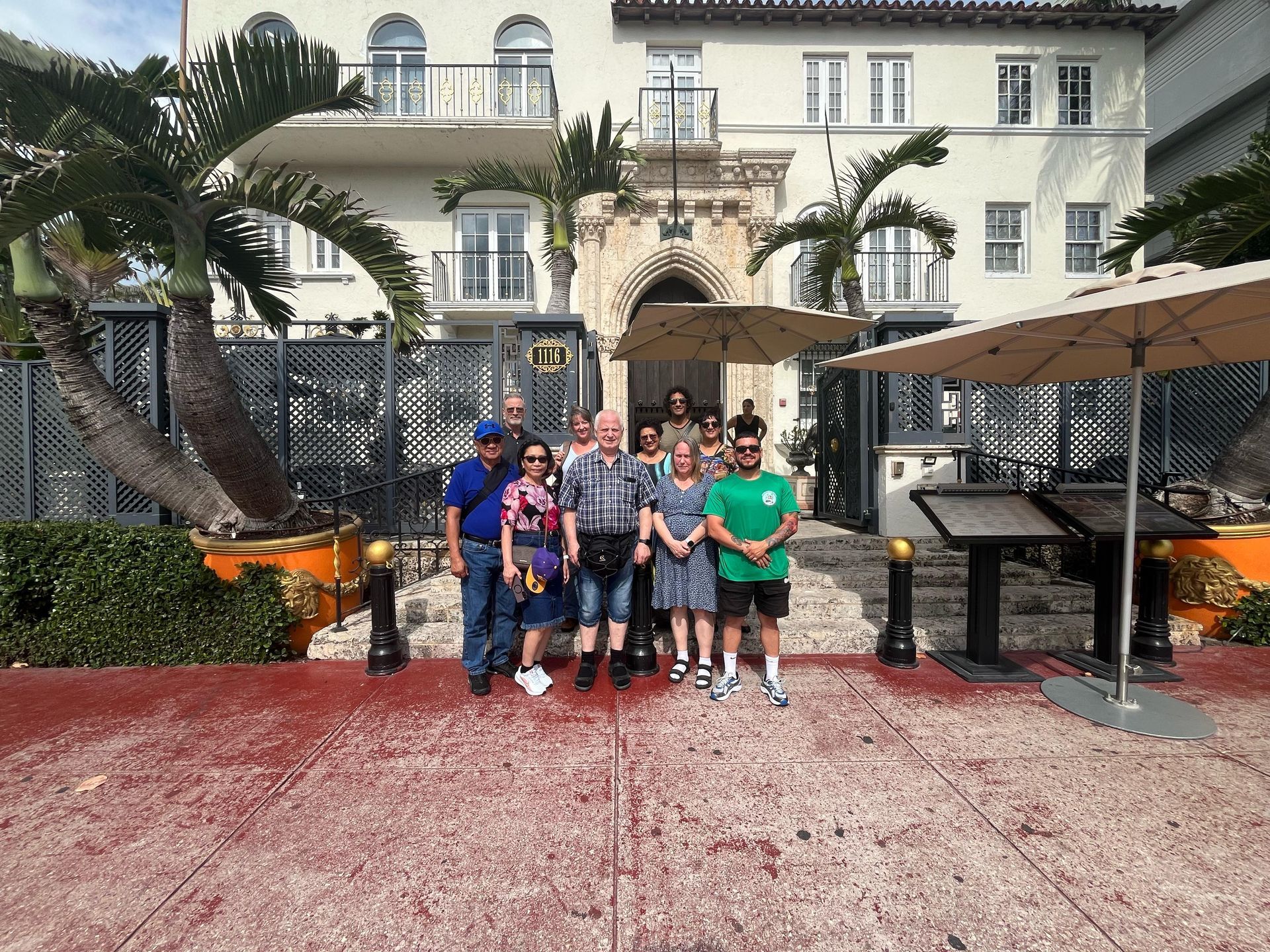 Tour group in front of the Versace Mansion during a sightseeing Miami bus tour
