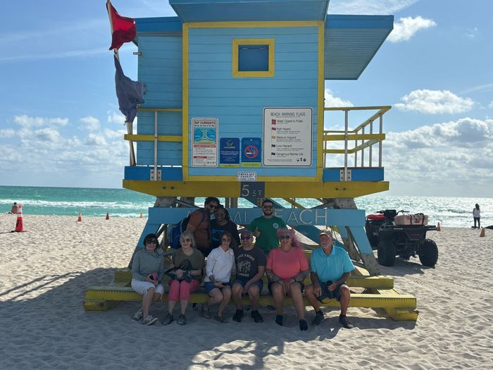 The only Miami Bus tour to give you beach access in the beach, passengers taking a selfie with the tour guide Alex. 