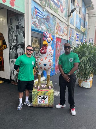 Tour guide and driver in little Havana taking a Selfie together in the famous Miami Little Havana Rooster Statue. 