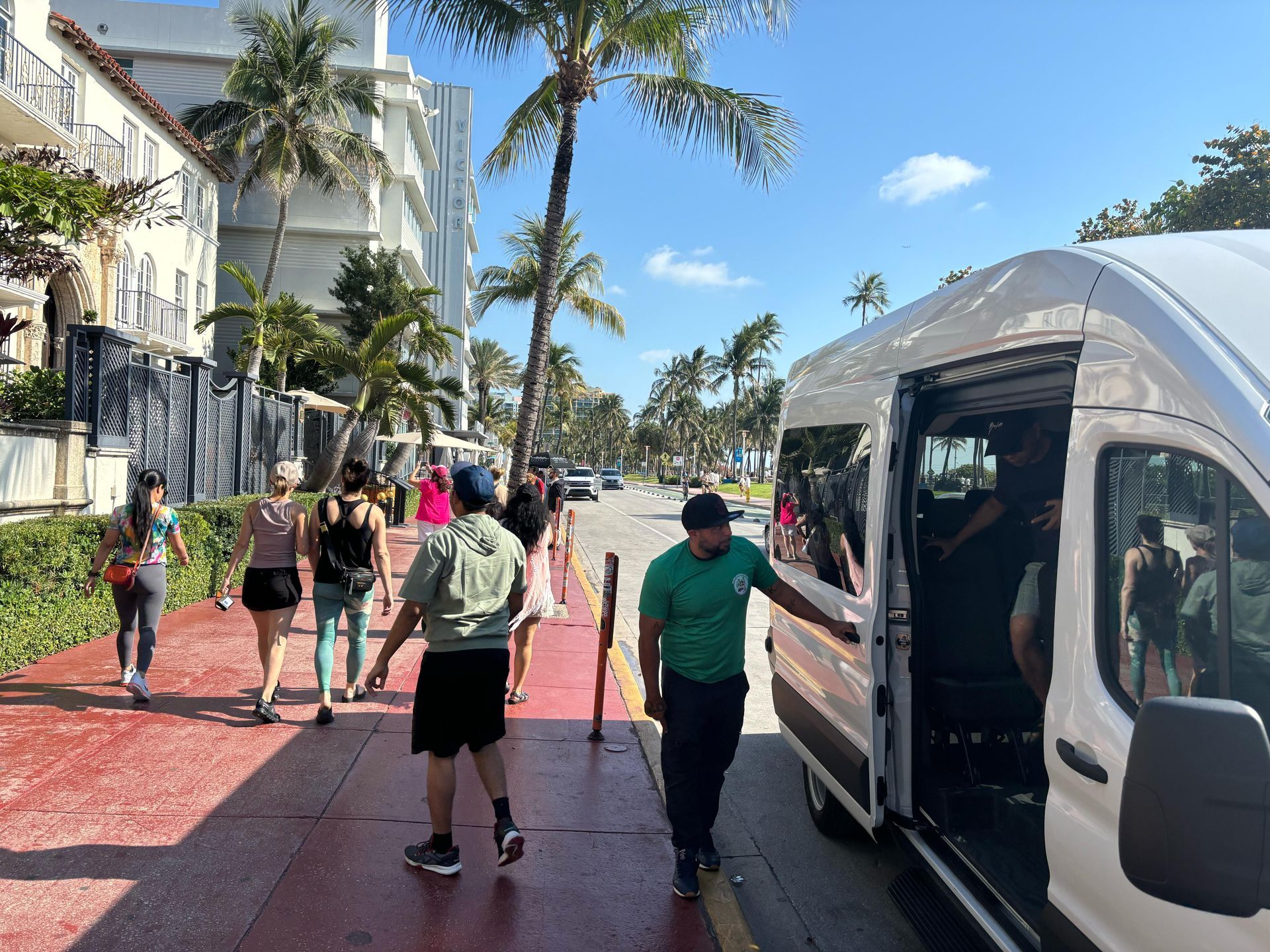 Miami Local City Tours white bus on Ocean Drive in South Beach with Angel the tour guide and passengers getting off to begin their walking tour
