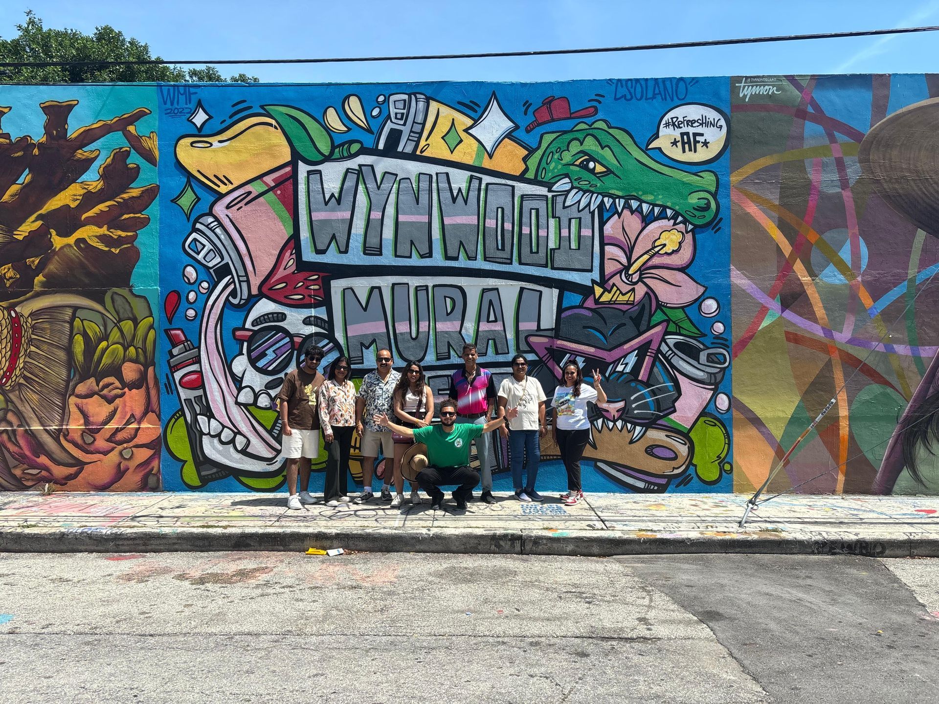 Miami Small Group Bus Tour in Wynwood Walls group photo of passengers with a colorful mural in the background