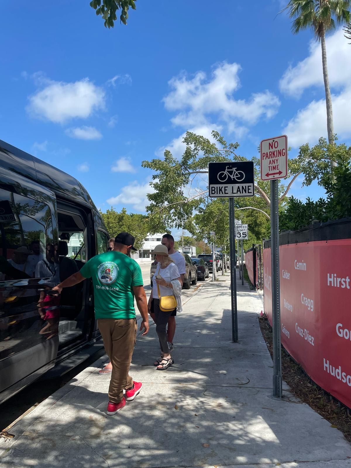 Guests boarding Miami city sightseeing bus with help from tour guide
