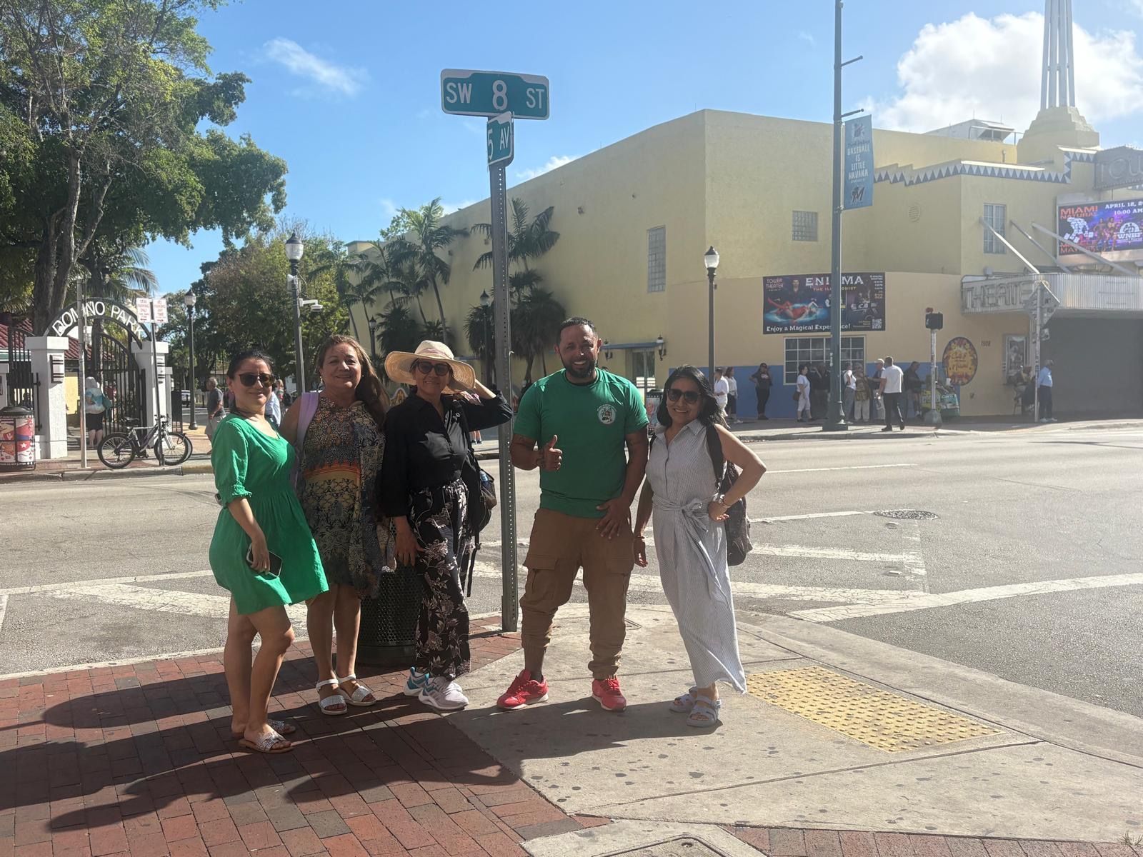 Group photo with Miami tour guide in front of Domino Park and SW 8th Street in Little Havana during a cultural city tour
