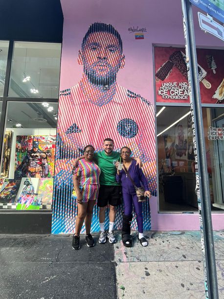 Miami bus tour stop at Wynwood Walls with Alex the tour guide taking a photo with passengers. 