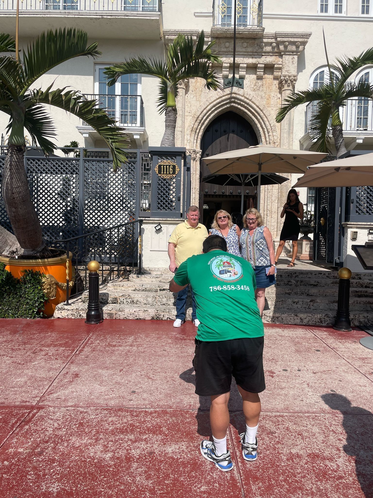 Miami Top City Tours guide taking a photo of happy guests at the Versace Mansion in South Beach
