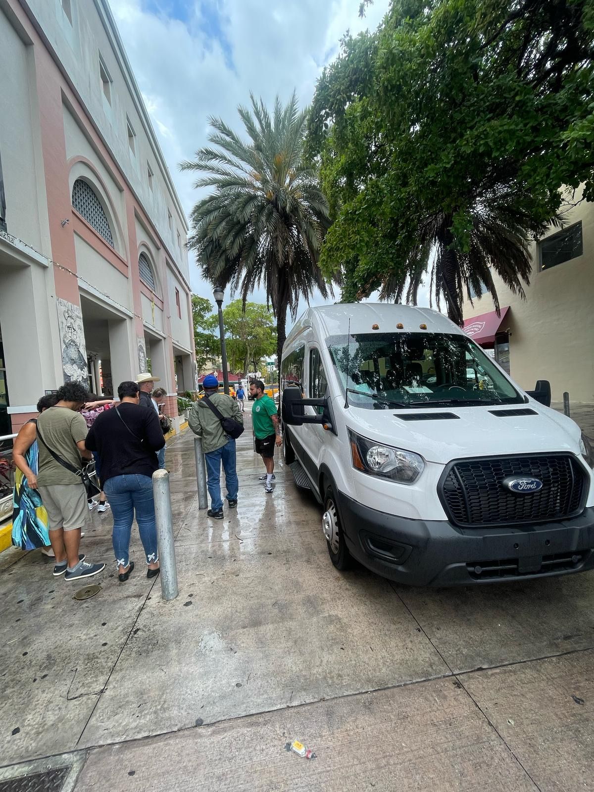 Tour group boarding sightseeing van in Little Havana on Miami cultural bus route
