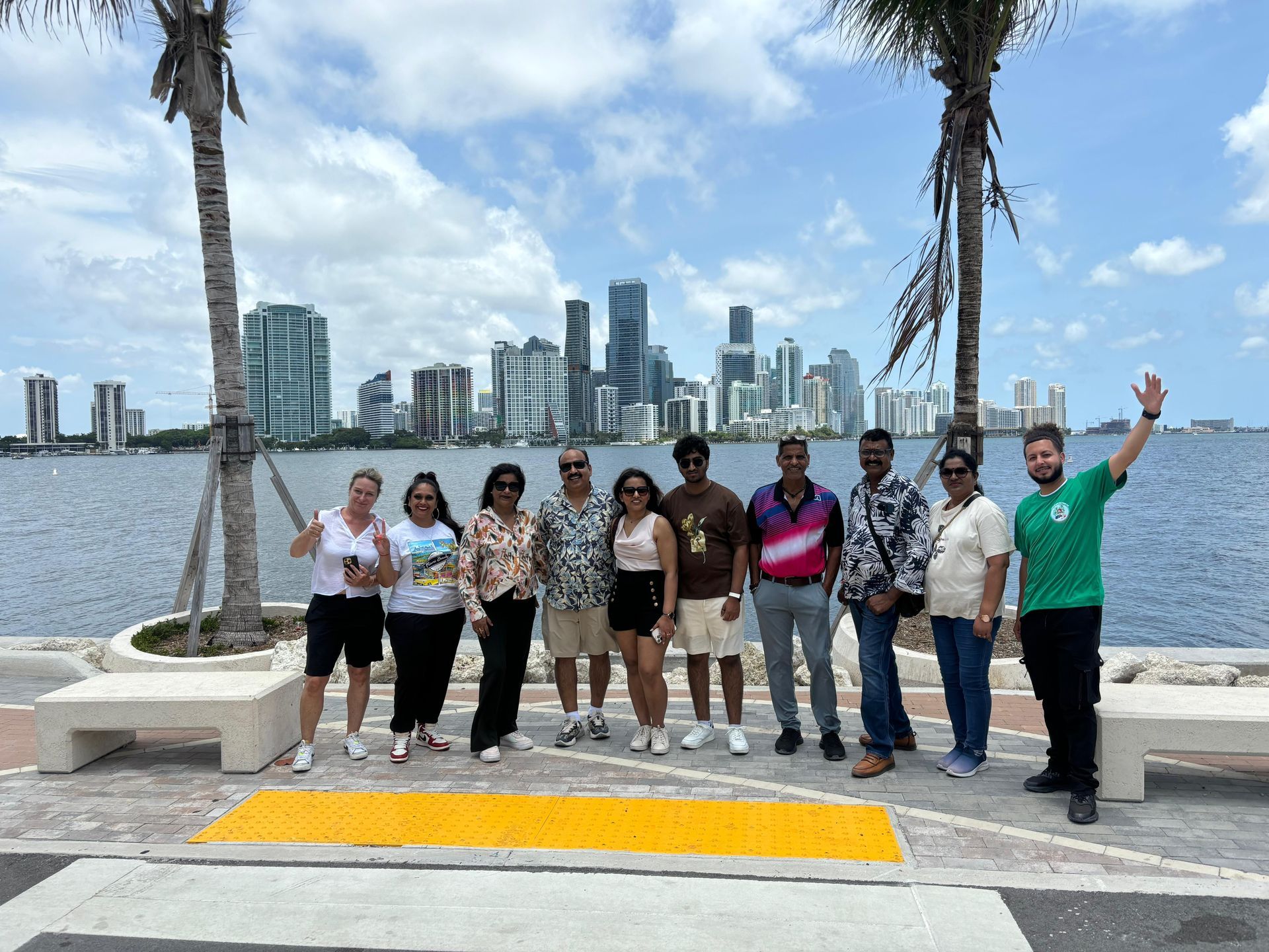 Small group Miami bus tour guests with tour guide in front of the Miami skyline
