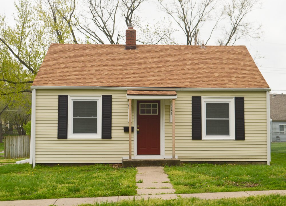 A small house with a red door and black shutters