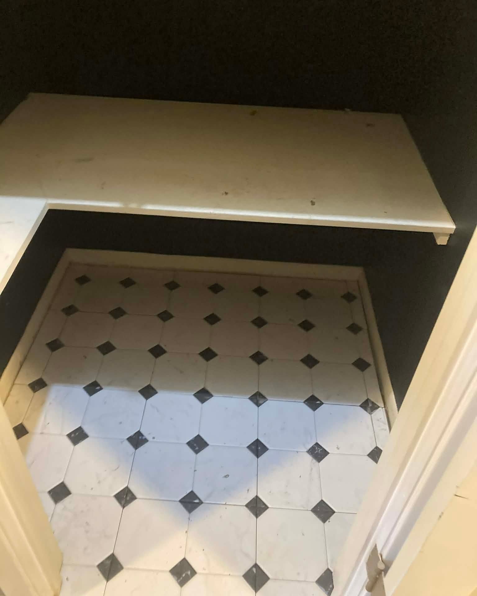 Open hatch reveals a tiled floor with a white and gray diamond pattern.