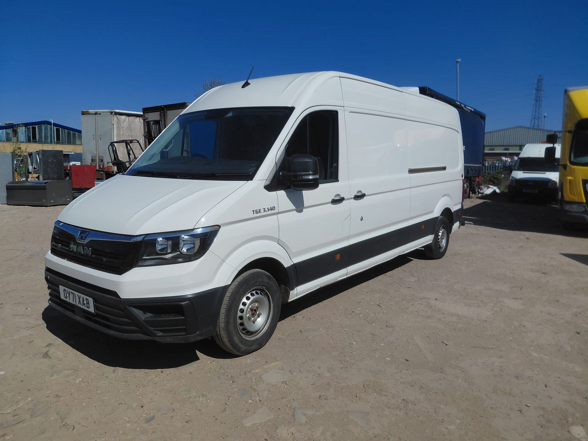 White cargo van parked on a dirt lot under a clear blue sky