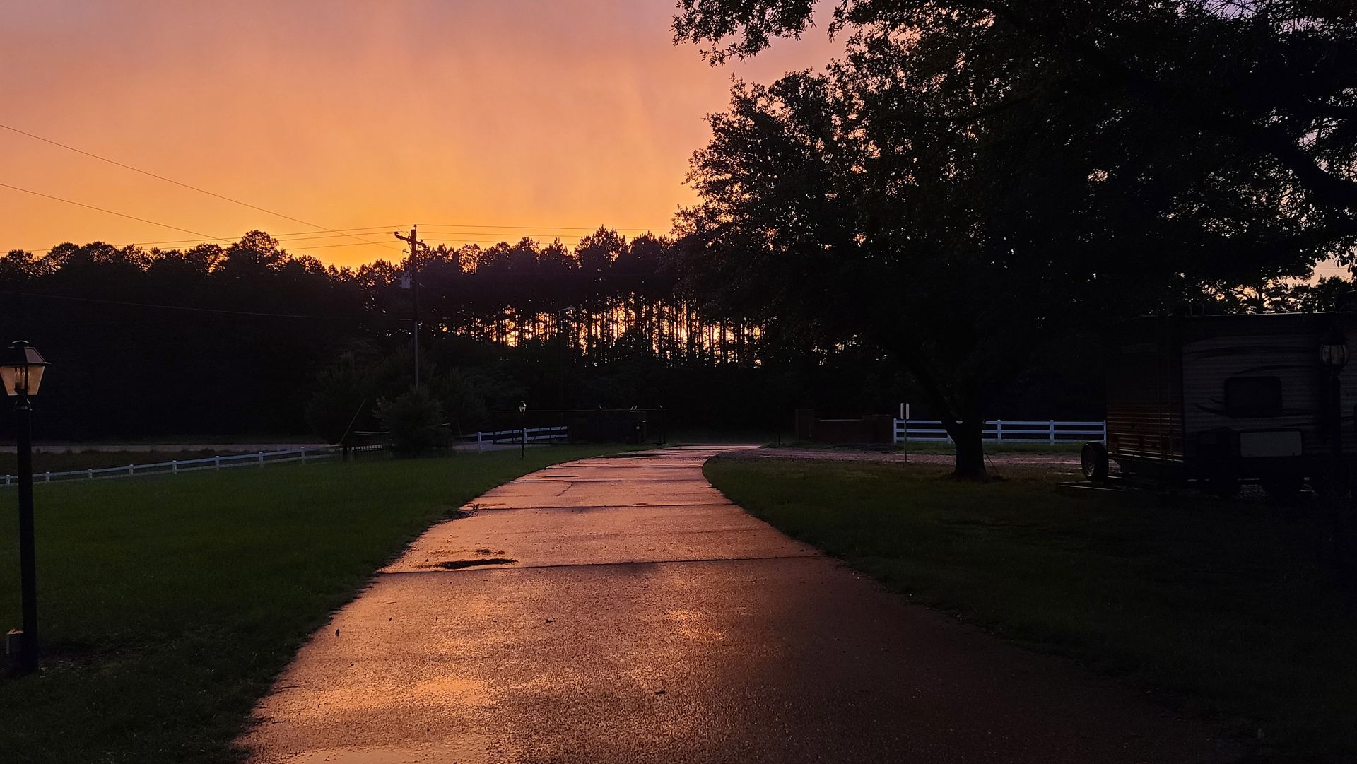 A path going through a field with a sunset in the background