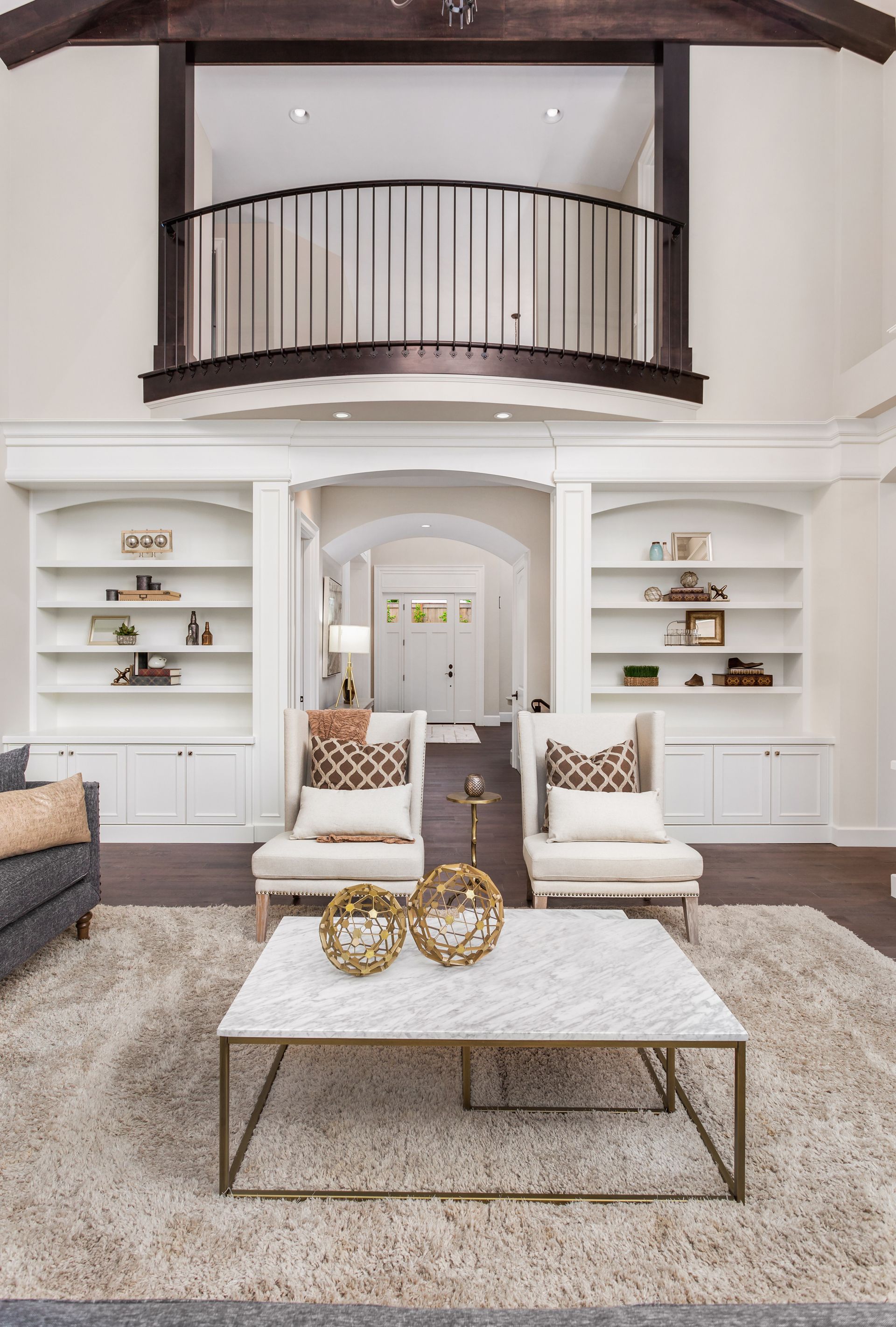 A living room with a couch , chairs , a coffee table and a balcony.