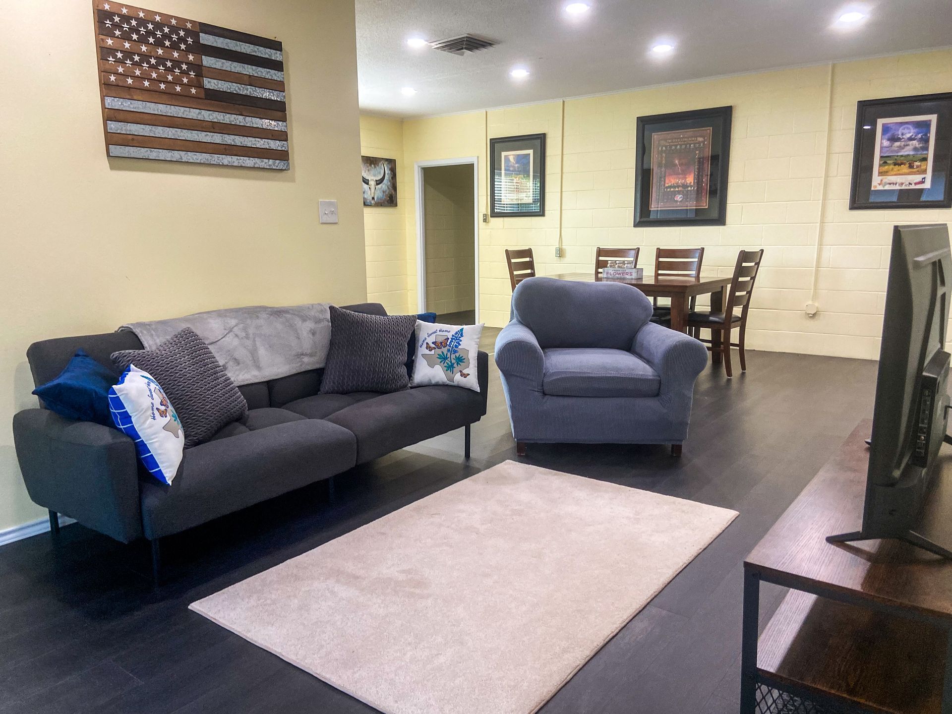 A living room with a couch , chair , table and television.