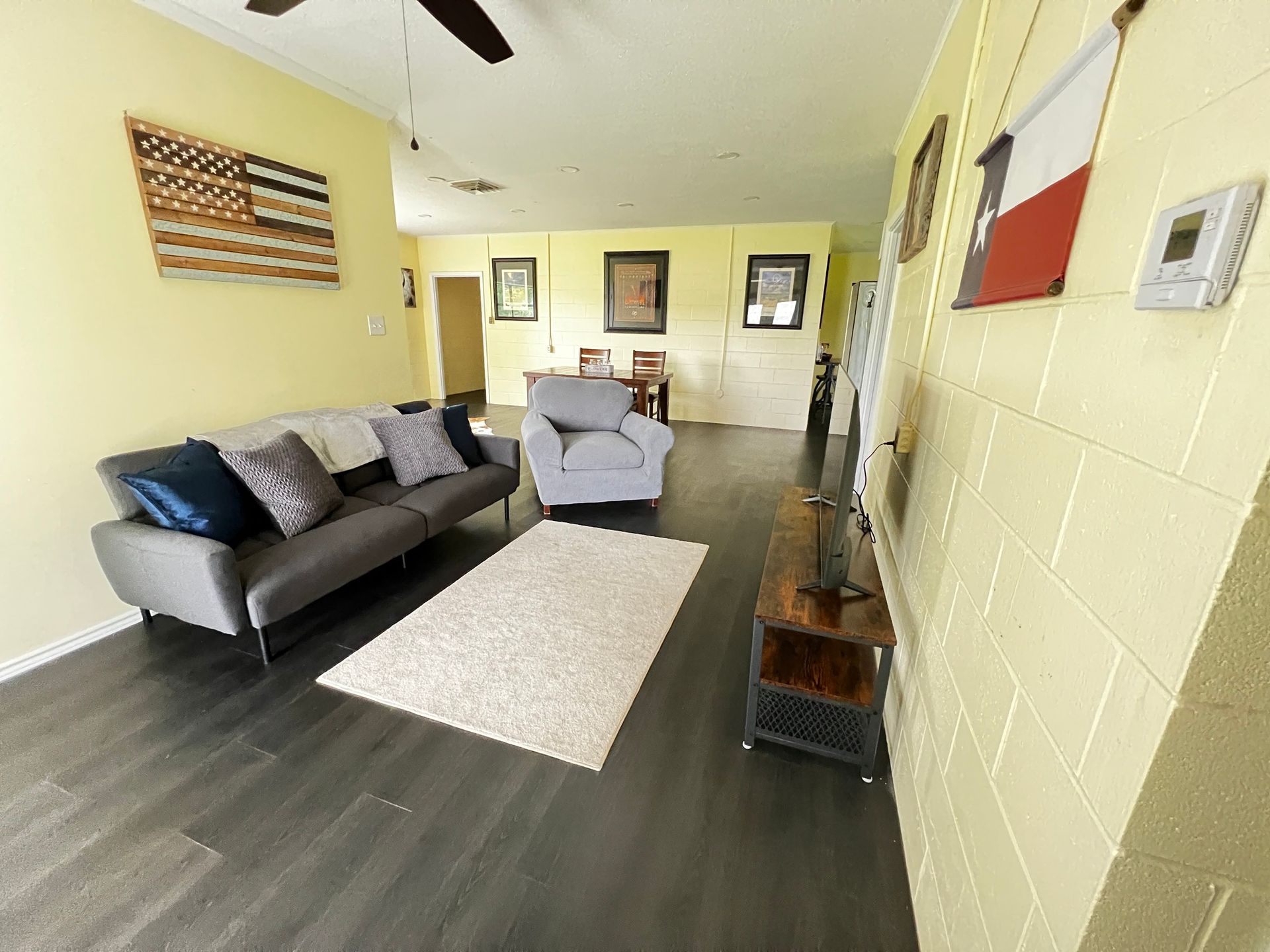A living room with a couch , chair , and television.
