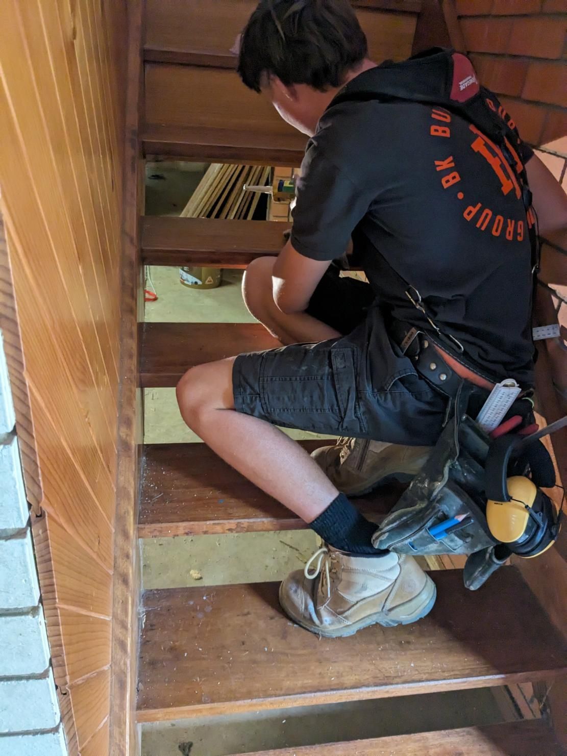 A Man is Sitting on a Set of Wooden Stairs — BK Build Group in Bellingen, NSW