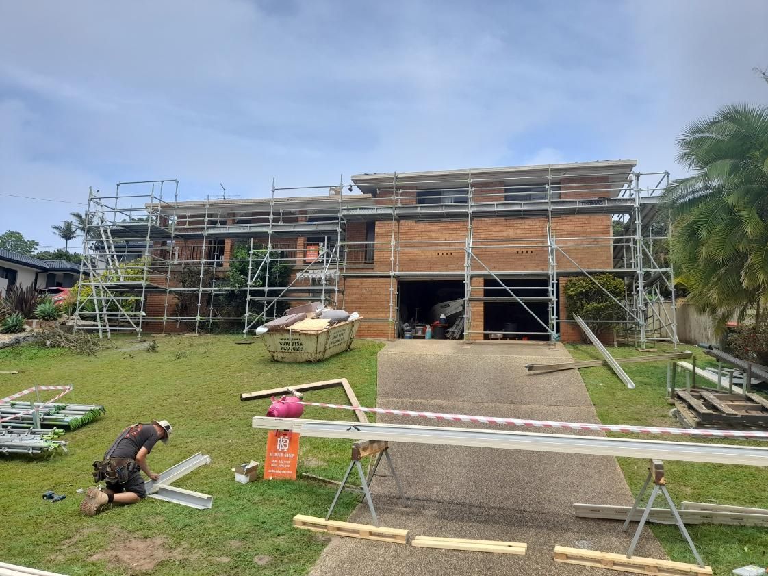 A Large Brick House is Being Built With Scaffolding Around It — BK Build Group in Woolgoolga, NSW