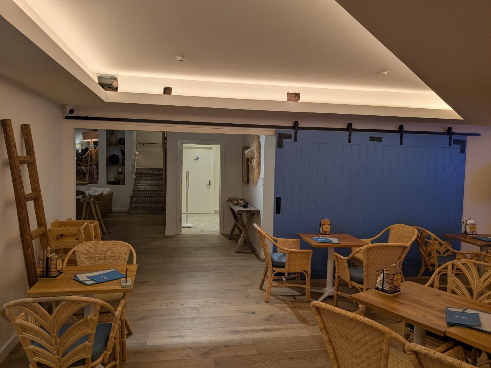 A Restaurant With Tables and Chairs and a Blue Wall — BK Build Group in Sawtell, NSW