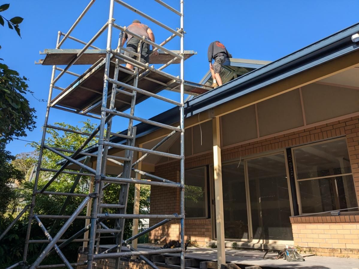 A Group of Men Are Working on the Roof of a House — BK Build Group in Nambucca Heads, NSW