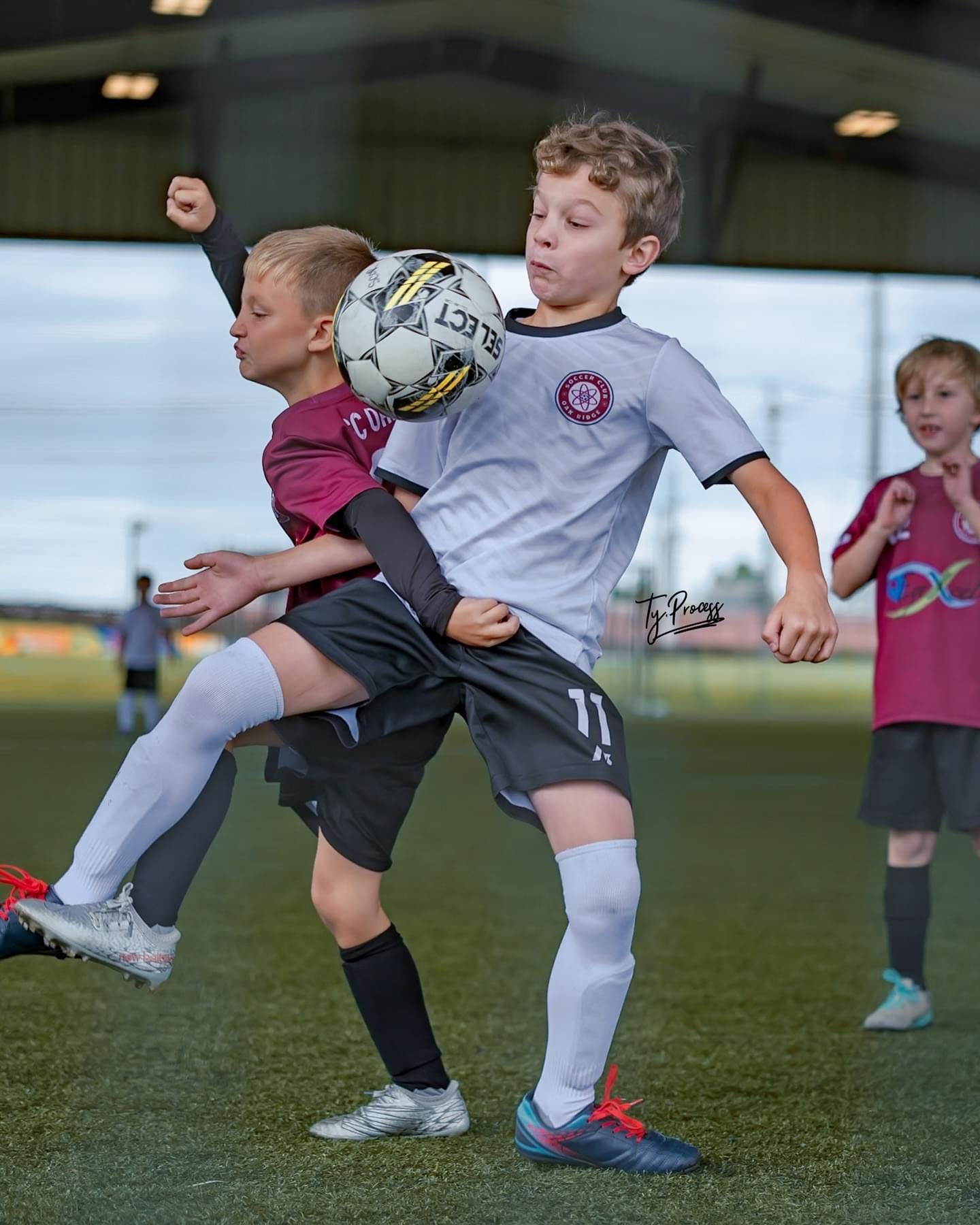 Two young boys are playing soccer on a field.