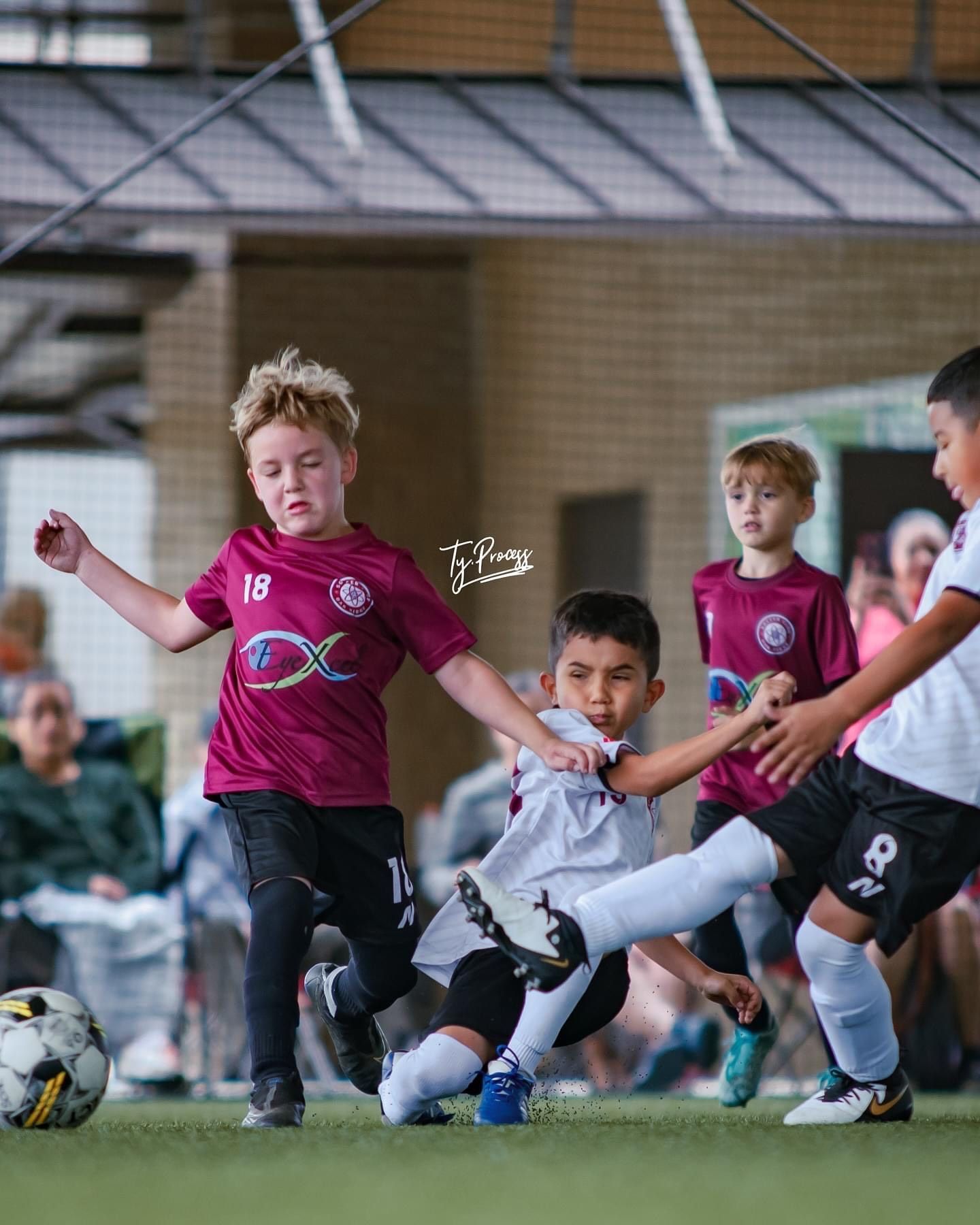 A group of young SCOR boys are playing soccer on a field.