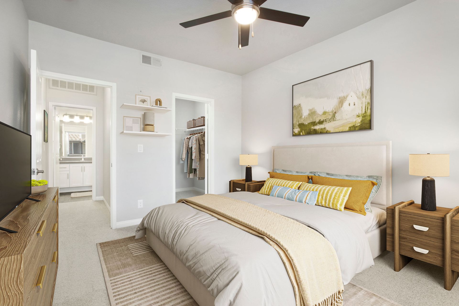 Bedroom with beige upholstered bed, two nightstands, dresser with TV, open closet, and ceiling fan at Alicante Apartments in Aliso Viejo, CA.